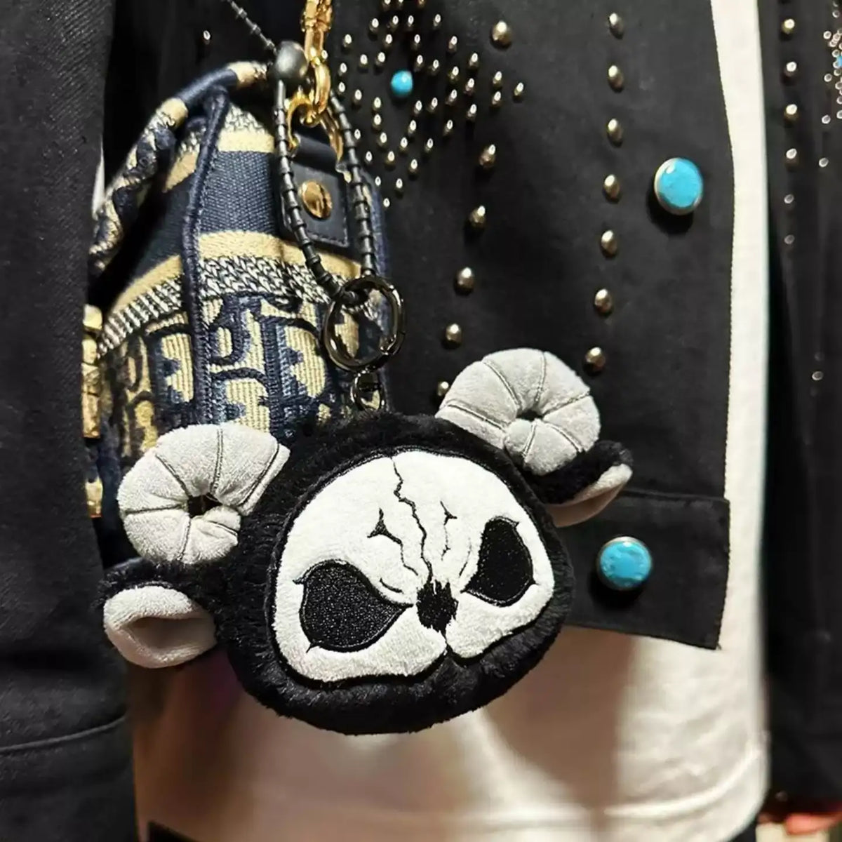 Dark Envoy Plush Charm Buu Evil hanging from a stylish outfit, featuring a unique horror-cute design.