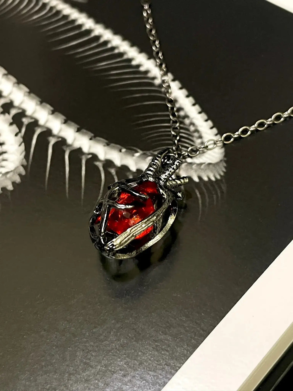 Soul Resonance Gothic Heart Necklace featuring a vintage-gothic heart with a red glass core on a silver chain.