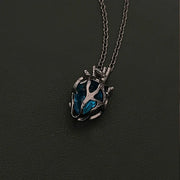 Soul Resonance Gothic Heart Necklace featuring a blue glass core wrapped in vintage filigree design.
