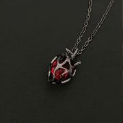 Soul Resonance Gothic Heart Necklace featuring a vintage-style heart with a red glass core and intricate filigree design.