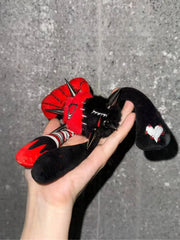 A person holding the Rivet Punk Rabbit plush charm featuring studs and a red-black color scheme.