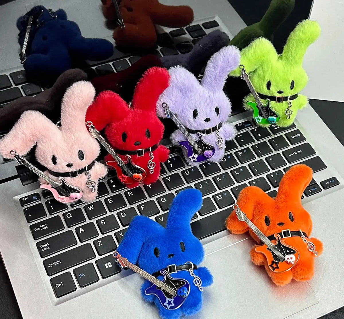 Guitarist Bunny Plush Charm collection featuring colorful plush rabbits with guitars on a laptop keyboard.