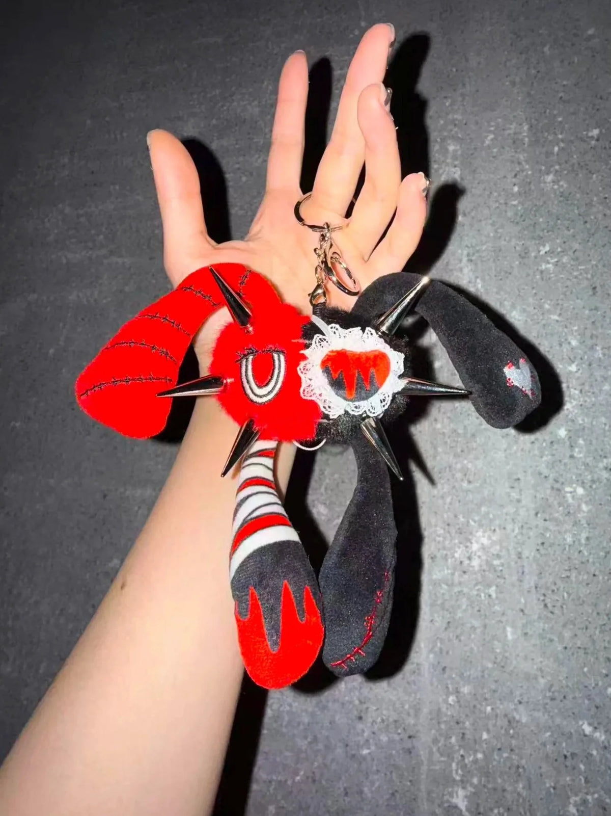 Rivet Punk Rabbit plush charm with spikes and a red-black color scheme held in a hand, showcasing unique punk kawaii style.