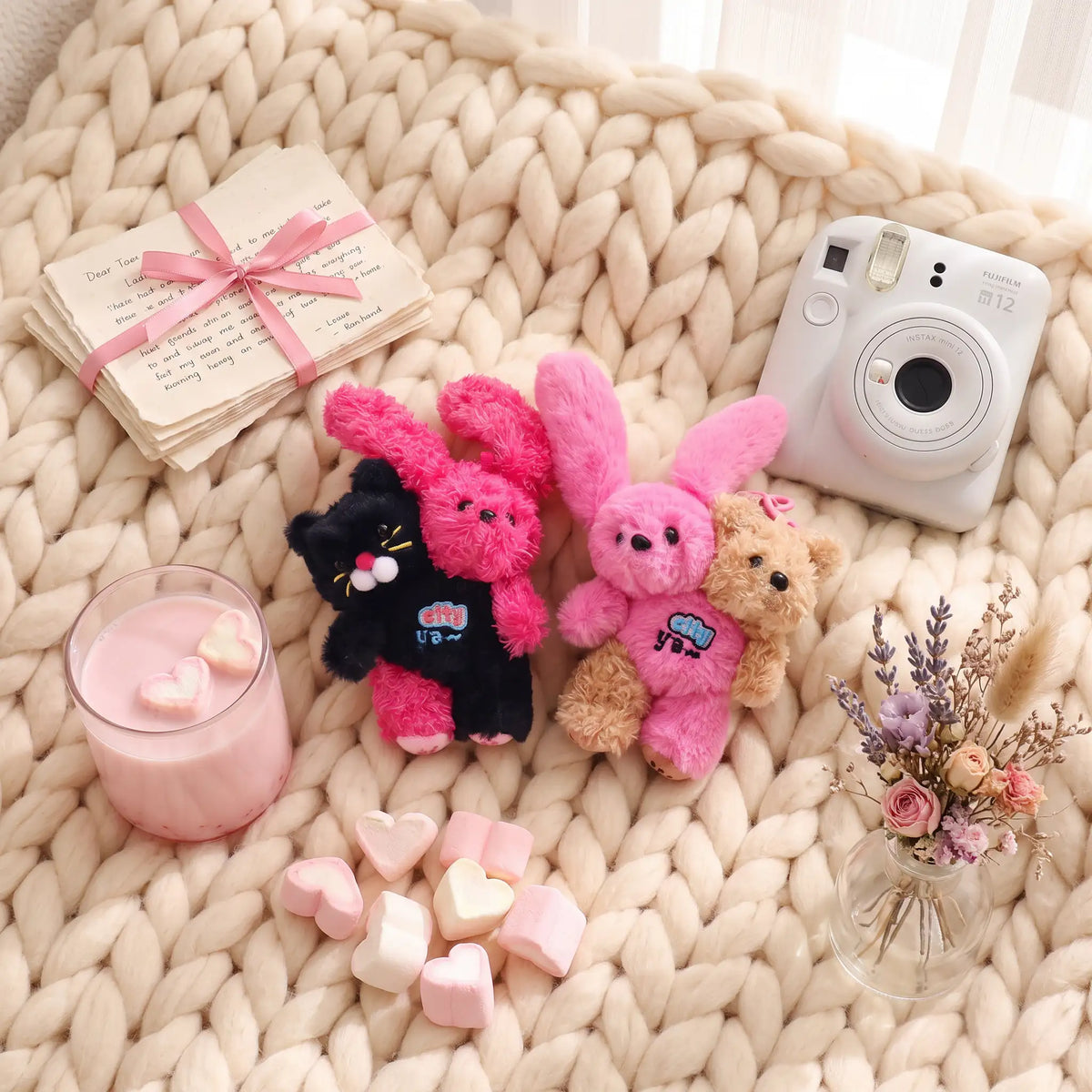 Cat Bunny Hugging Plush Charm alongside cute bunnies, a bear, and a camera on a cozy blanket.