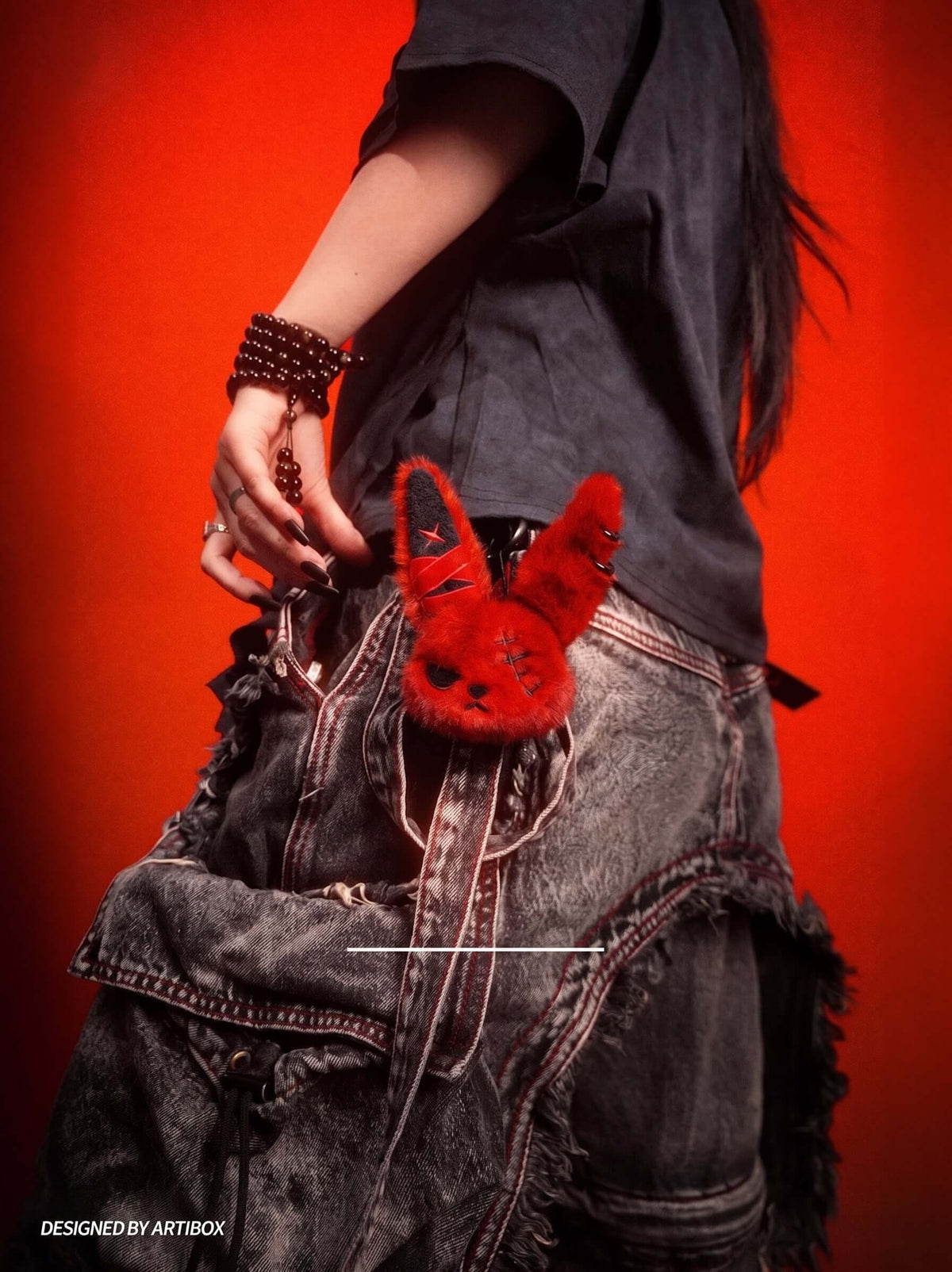 Cuddly Bunny - DarkCute BandaBun plush accessory seen on a person's outfit, featuring vibrant red color against a dark background.