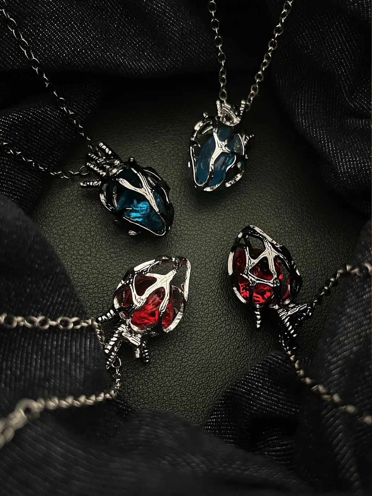Soul Resonance Gothic Heart Necklace showcasing four vintage gothic hearts with red and blue glass cores.