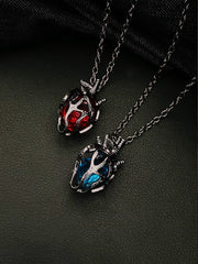 Soul Resonance Gothic Heart Necklace featuring red and blue glass hearts in vintage gothic filigree design.