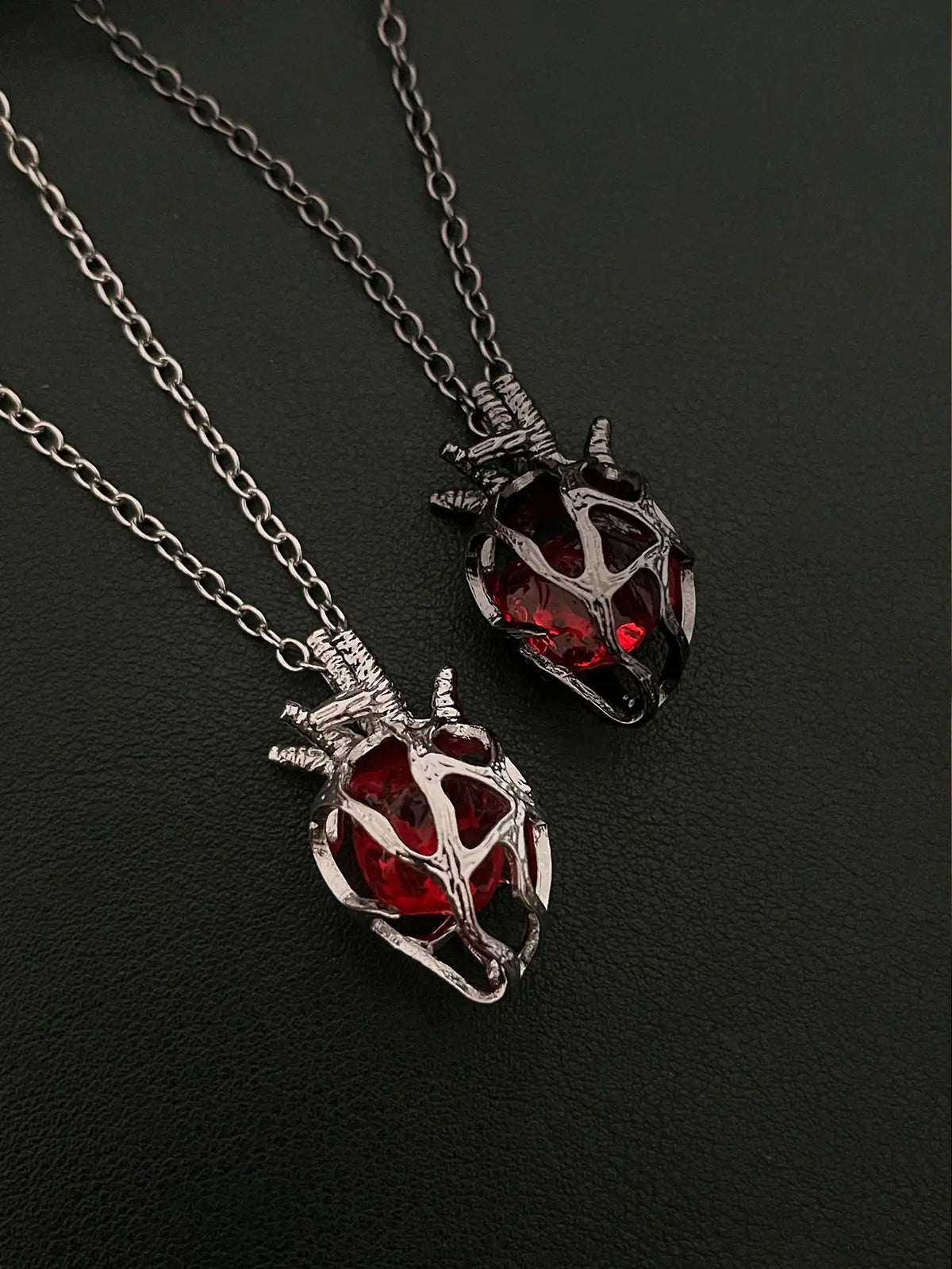 Soul Resonance Gothic Heart Necklace featuring two vintage-gothic heart pendants with red glass cores.
