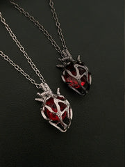 Soul Resonance Gothic Heart Necklace featuring two vintage-gothic heart pendants with red glass cores.