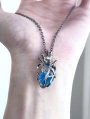Soul Resonance Gothic Heart Necklace featuring a blue glass heart in intricate filigree on a chain.