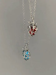 Soul Resonance Gothic Heart Necklace featuring red and blue glass hearts in silver filigree design.