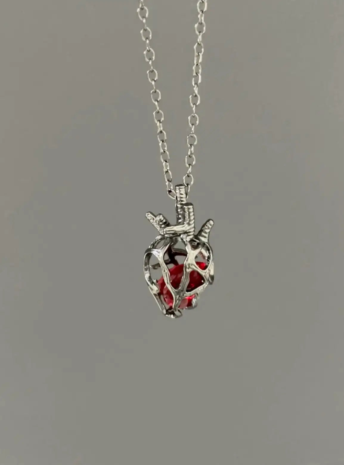 Soul Resonance Gothic Heart Necklace featuring silver filigree heart with red glass core on a delicate chain.