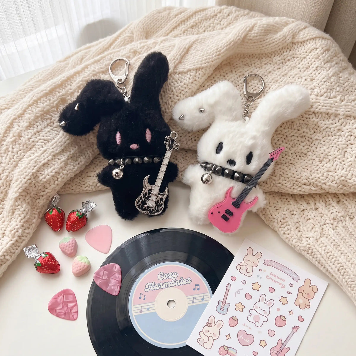 Guitarist Bunny Plush Charm featuring black and white bunny plushies with guitars and accessories on a cozy background.