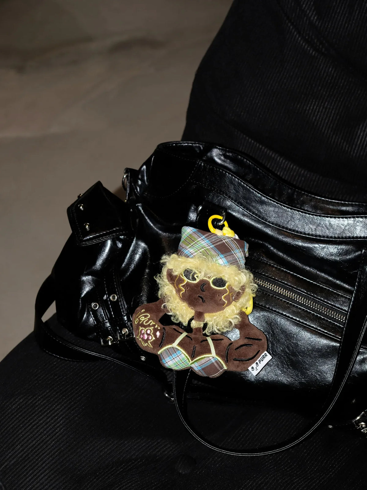 Buu Evil Plush Bag Charm on a stylish black handbag, showcasing its playful design and muscular features.