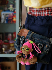 Buu Evil plush bag charm hanging from a denim bag, showcasing its muscular design and vibrant colors.