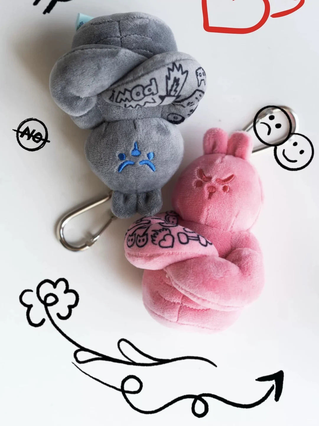 Grey and pink muscle bunny plush keychains with tattoo sleeves and doodle background, kawaii fitness bag charms