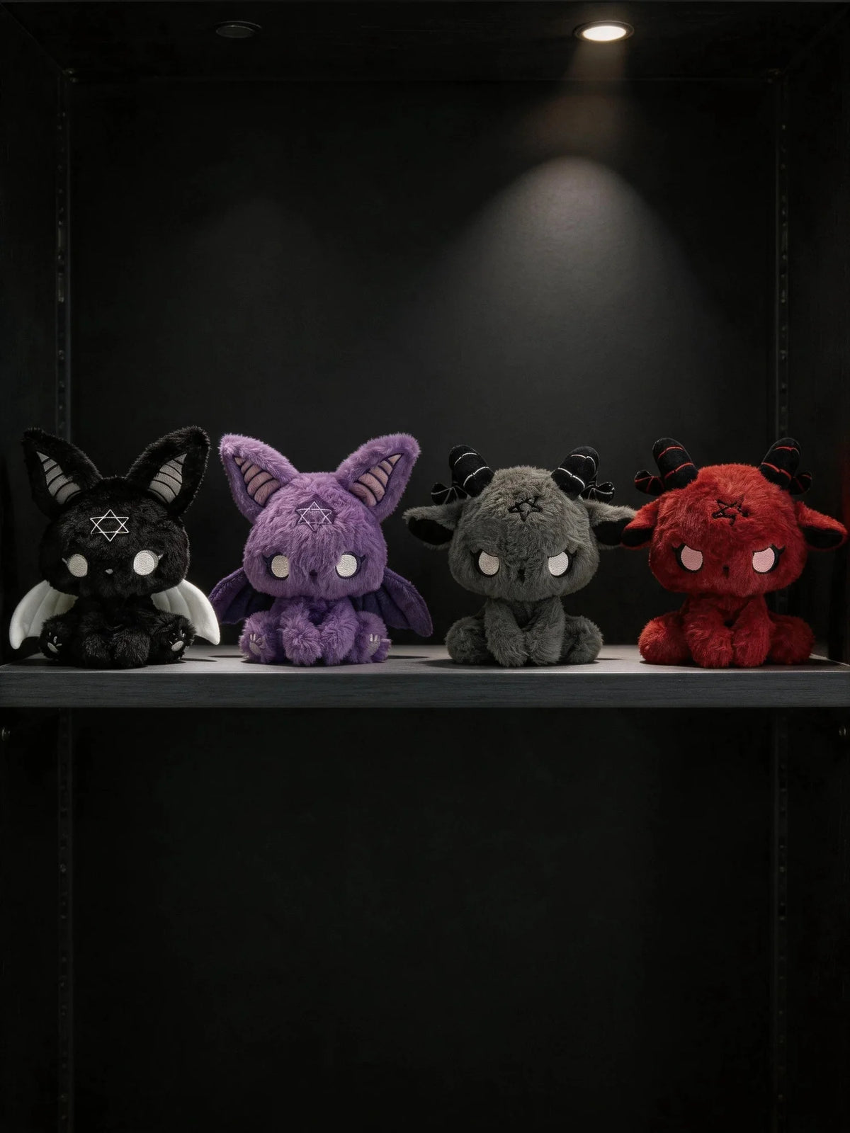 Dark Envoy Gothic Cute Plush Doll - Buu Evil lined up on a shelf, featuring black, purple, grey, and red designs.