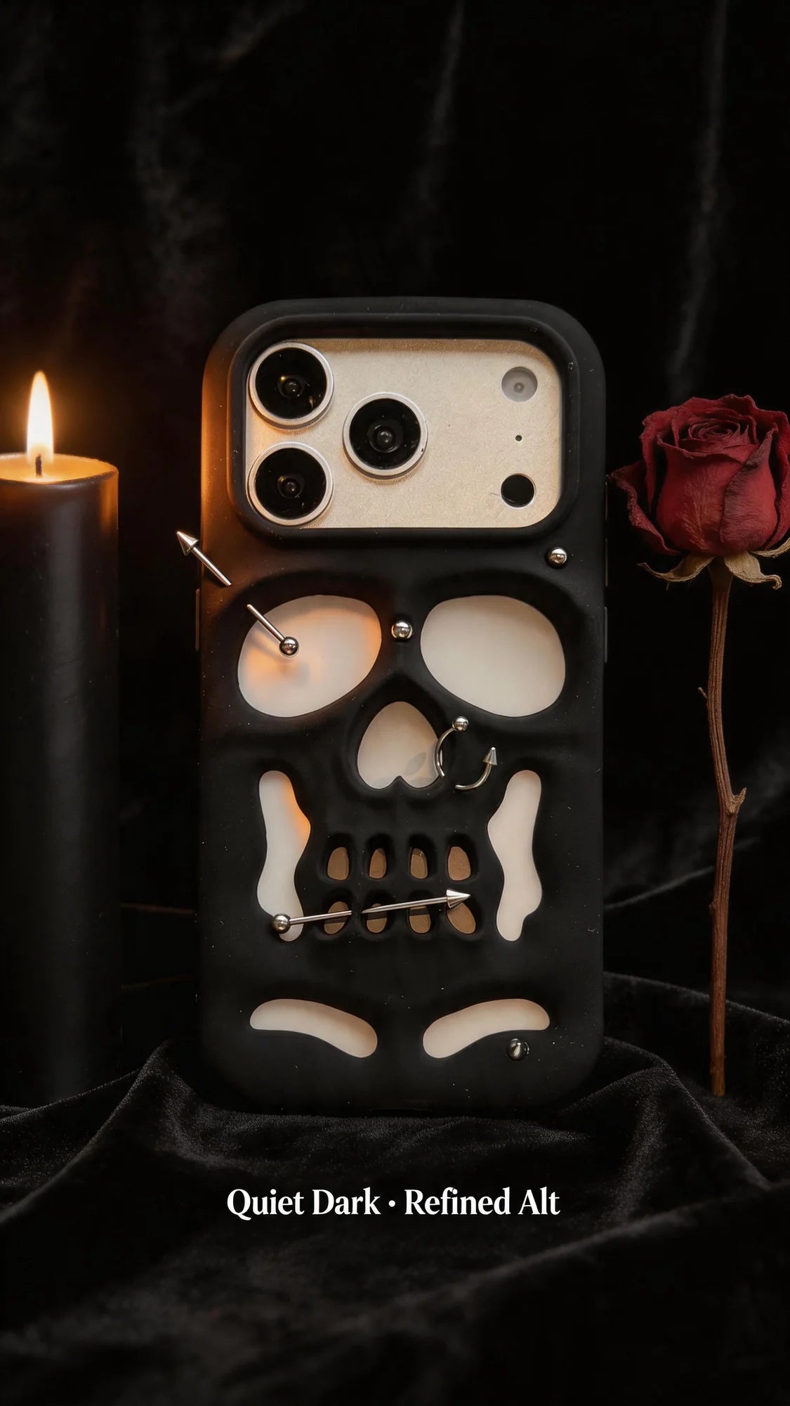 Buu Evil:Gothic punk skull studded iPhone case displayed next to a candle and red rose on a dark background.