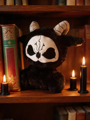 Dark Envoy Reaper Plush - Buu Evil sitting on a shelf with books and candles, featuring its cute and sinister design.