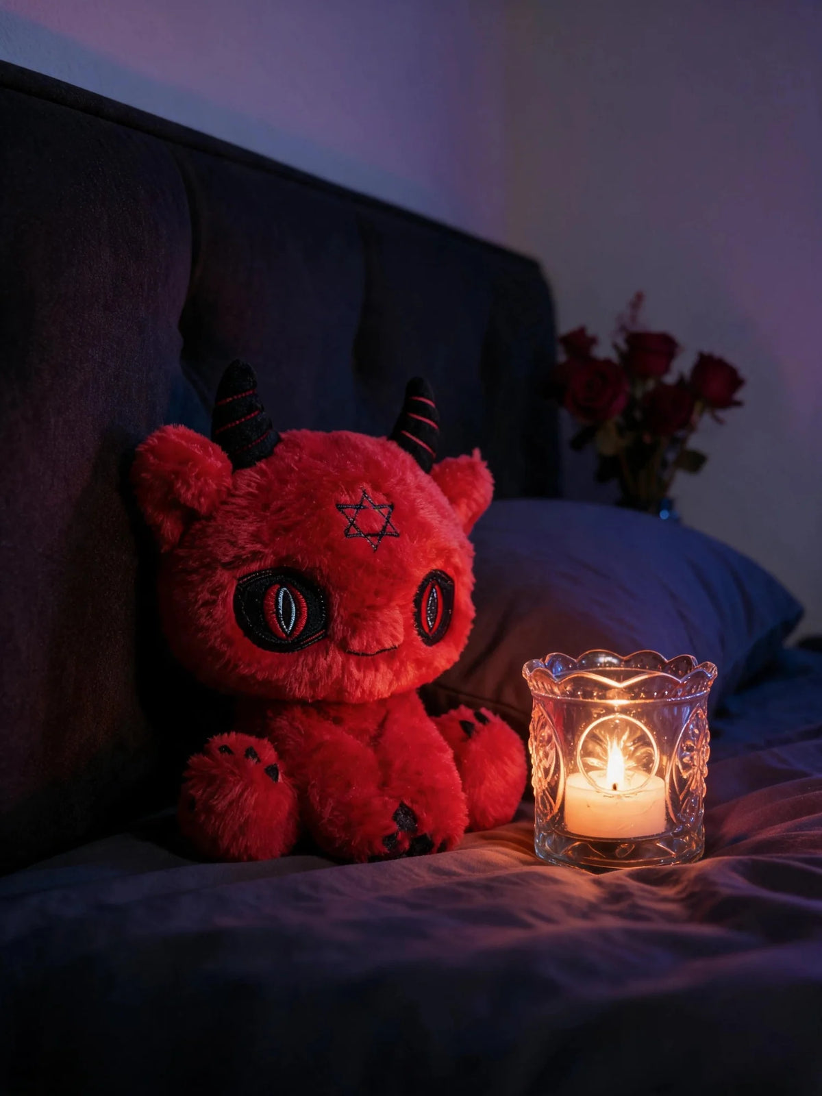 Dark Envoy Reaper Plush - Buu Evil beside a candle on a bed, creating a cozy and charming atmosphere.