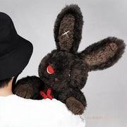 Person holding cuddly bunny - Sulky Sourbun plush toy with dark brown fur and red accents.