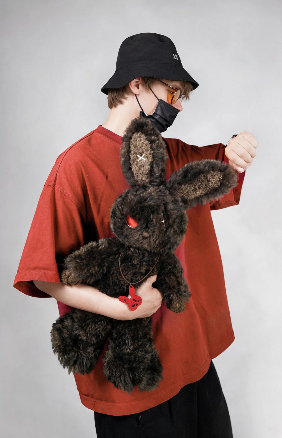 Cuddly bunny - Sulky Sourbun plush toy held by a person in a red shirt and black bucket hat.