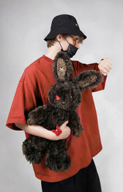 Cuddly bunny - Sulky Sourbun plush toy held by a person in a red shirt and black bucket hat.