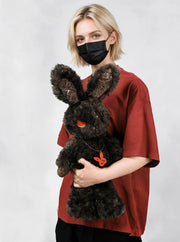 Cuddly bunny - Sulky Sourbun plush toy held by person, showcasing its soft dark brown fur and unique design.