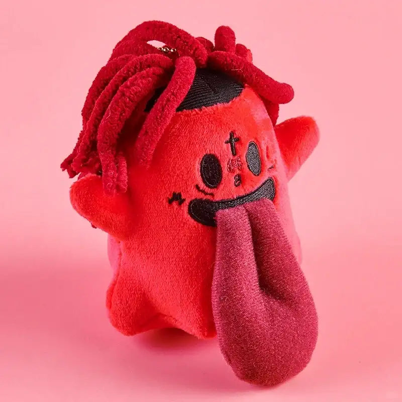 Monster Crew Plush Bag Charm featuring a cute red monster with floppy hair and a playful tongue, set against a pink background.